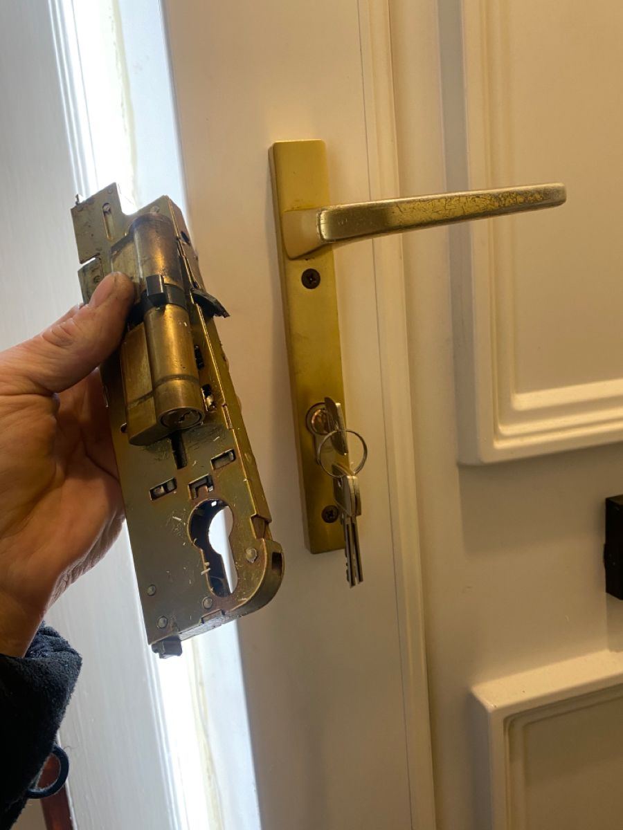 A gold multipoint gearbox held beside a white panelled door