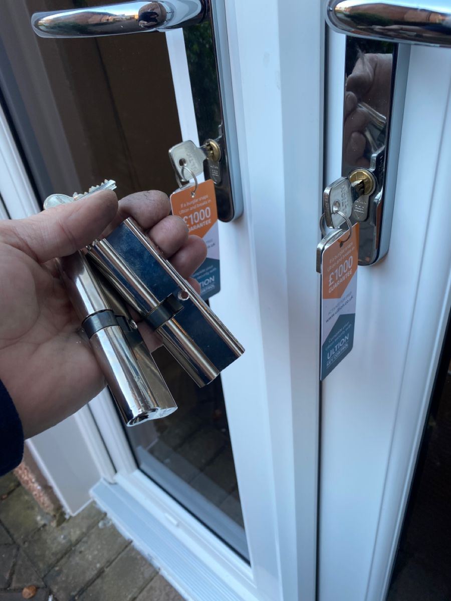 Two chrome Ultion anti-snap cylinders removed from a set of French doors