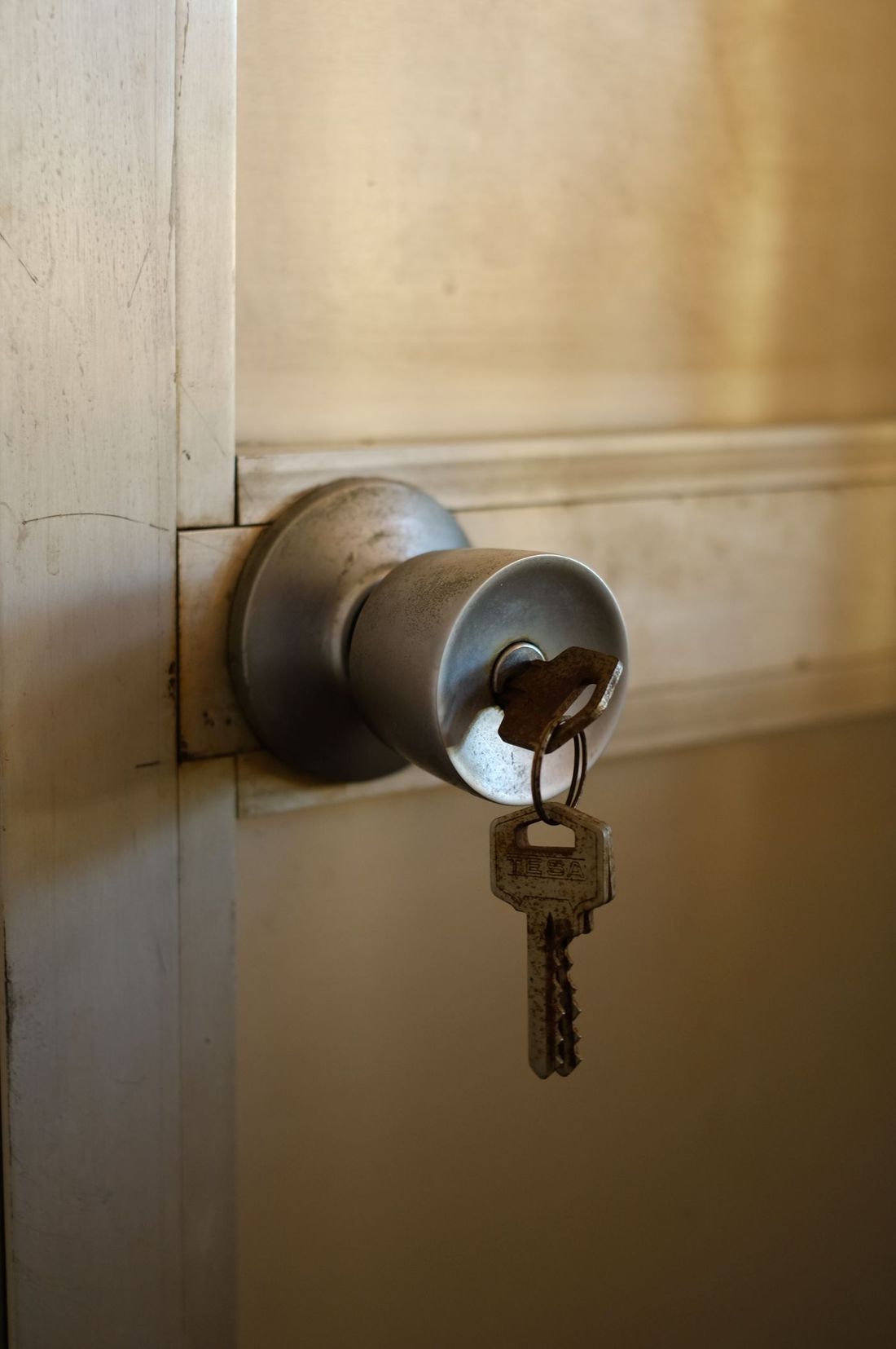 A key being worked into a night latch on a front door