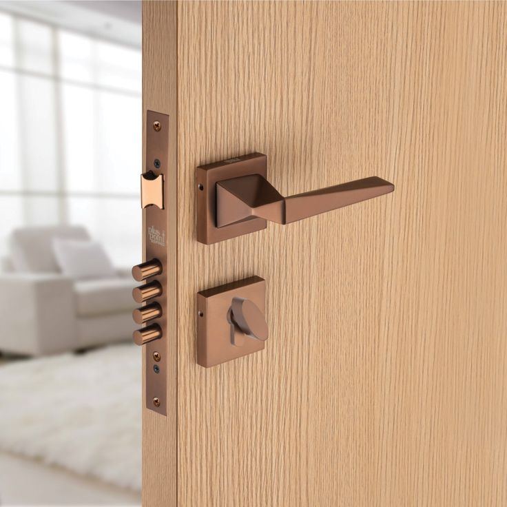 A mortice lock and bronze lever handle fitted into the edge of a timber door